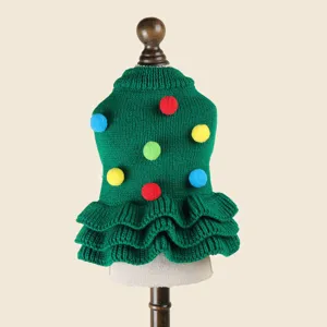 Dettaglio del maglione verde in maglia per animali con pon-pon colorati e design di albero di Natale.