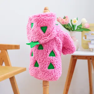Nahaufnahme Detail der rosa Pluesch Haustierkleidung mit gruenen Stacheln, weiches Fleece Material.