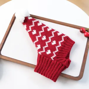 Vue détaillée du bonnet en tricot rouge et blanc avec pompon pour petits chiens et chats.
