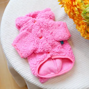 Pink plush pet coat detail, soft fleece winter warm puppy clothes with cozy texture close up.