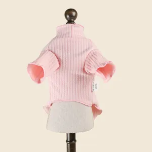 Dettaglio maglione lavorato a maglia rosa per cani, texture a coste, colletto alto, vestiti.