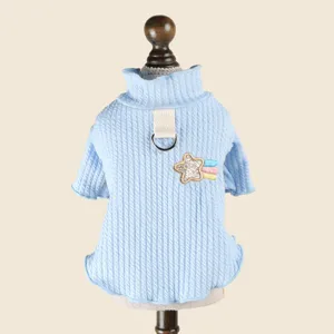 Dettaglio maglione dolcevita azzurro per animali con anello D e ricamo a stella.