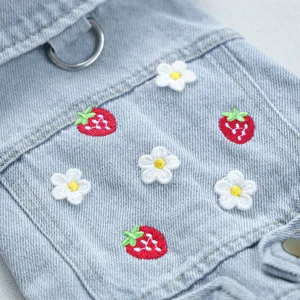 Detailansicht süßer Haustier-Jeanskleidung mit Erdbeer- und Gänseblümchen-Stickerei, weicher Stoff