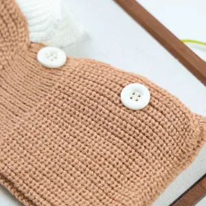 Detailed shot of cute pet knitted hat with ruffles and buttons for small dogs cats in autumn.