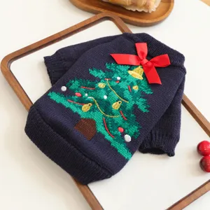 Close-up detail of the knitted pet Christmas sweater featuring tree embroidery and red bow.
