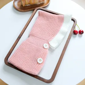Cute pink pet knitted hat detail showing soft wool texture, white ruffles and sweet button accents.