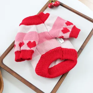 Vista detallada del bonito suéter para mascotas con rayas rojas y rosas y motivos de corazones.