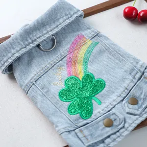 Close-up of pet denim jacket featuring sparkling rainbow and green four-leaf clover patch.
