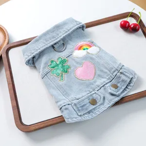 Cute denim pet jacket for small dogs, featuring embroidered clover and rainbow patches, detail view.