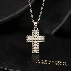Close-up van elegante strass en parel kruis hanger ketting met fijne zilveren ketting.