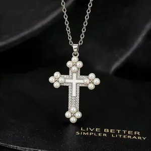 Gedetailleerd overzicht van een elegante zilveren kruisketting met parels en sprankelende zirkonia.