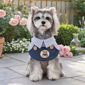 Dettaglio bavaglino per animali con colletto a righe blu e ricamo di orsetto dolce.