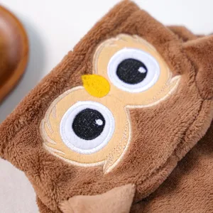 Close-up detail of soft brown plush pet costume featuring cute embroidered owl face design.