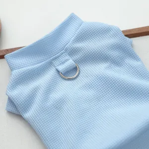 Gros plan detail de vetements pour animaux bleu clair avec harnais anneau D, tissu.