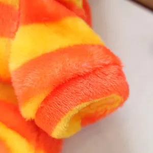 Close-up detail of cute warm pet clothing plush fabric with soft orange and yellow stripes.