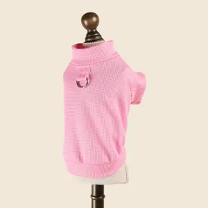Détail pull pour animal en tricot gaufré rose, col haut et anneau de fixation pour laisse.