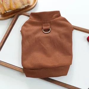Détail d'un pull pour animaux de compagnie en tricot gaufré marron avec anneau de laisse.