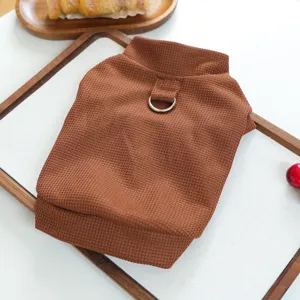 Gros plan détaillé d'un pull pour animaux marron en tricot gaufré avec anneau D en métal.