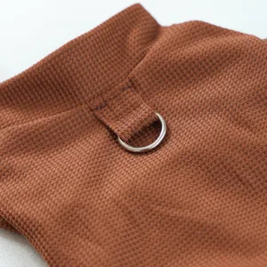 Gros plan detail vetement animal en tricot gaufre marron avec anneau de traction en metal