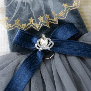 Grijs fluwelen huisdierjurk detail met gouden kant, blauwe strik en strass kroon.