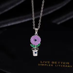 Nahaufnahme einer silbernen Topfblumen Anhänger Halskette mit lila Emaillierung.