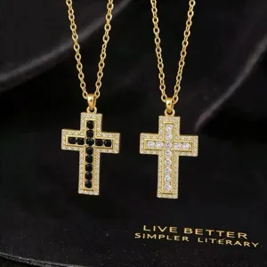 Detailopname van een sprankelende kruis hangketting met zirkonia stenen en gouden ketting.