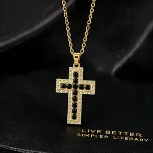 Gouden vintage kruis ketting met schitterende zirkonia en zwarte stenen voor dames.