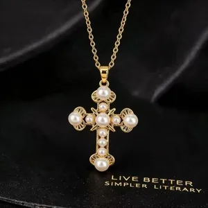 Gedetailleerde close-up van een vintage gouden kruishanger halsketting met parels.