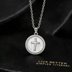 Detailopname van de elegante vergulde kruis ketting met glinsterende zirkonia hanger.