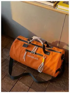 Orange cylinder duffel bag detail, waterproof fitness gym bag with spacious storage capacity.
