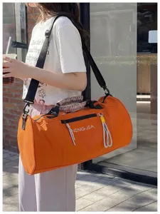 Detailed view of the large orange cylindrical fitness gym duffel bag with shoulder strap.