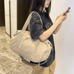 Spacious beige travel duffel bag for gym and short trips with comfortable shoulder strap.