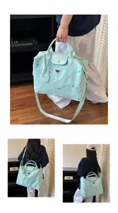 Close-up detail of light mint green large capacity travel duffel bag with shoulder strap.