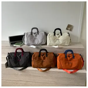 Detailed shot of various colored travel duffel bags showing large capacity and handy straps.