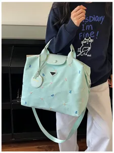Mint green large travel duffel bag with cute bow embroidery, comfortable shoulder strap detail.