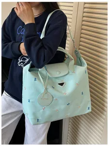 Large capacity casual tote bag for women, stylish embroidered travel shoulder handbag.