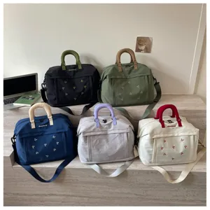 Vista dettagliata di borsoni da viaggio in tela di grande capacità su un ripiano.
