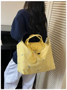 Large capacity yellow nylon travel shoulder bag with cute butterfly embroidery for commute.