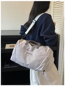 Large capacity travel duffel bag in light gray with shoulder strap and stylish design details.