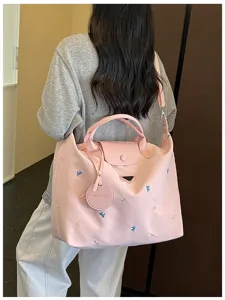 Pink large capacity travel shoulder bag detail, embroidered bow design for casual commuting fitness.