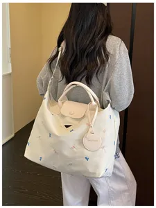Korean style large capacity canvas travel tote bag with embroidery details and shoulder strap.