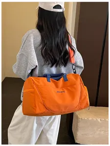 Large capacity travel duffel bag detail, orange gym bag worn on model back view design.