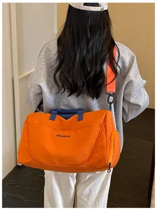 Detailed view of the large capacity travel duffel bag with crossbody strap and sturdy handles.
