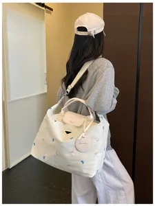 Large capacity canvas travel tote bag with shoulder strap and chic embroidery for daily commute.