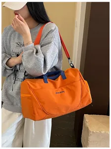 Large capacity travel duffel bag with stylish orange design, dual handles and comfortable strap.