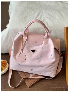 Pink large capacity travel duffel bag with butterfly embroidery, sturdy handles and strap.