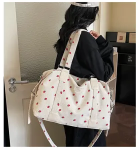 Detail view of large capacity corduroy travel duffel bag with cute strawberry print for women.