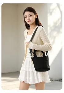 Sac seau en toile noire avec bandoulière réglable, style crossbody minimaliste pour femme.