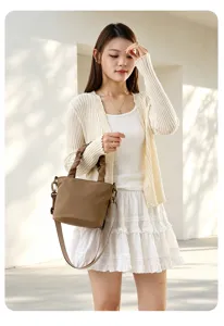 Vue détaillée du sac seau en toile marron élégant porté par le mannequin, simple et tendance.