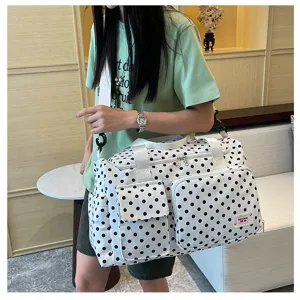 Close-up of the stylish polka dot travel duffel bag showing multiple front pockets and details.